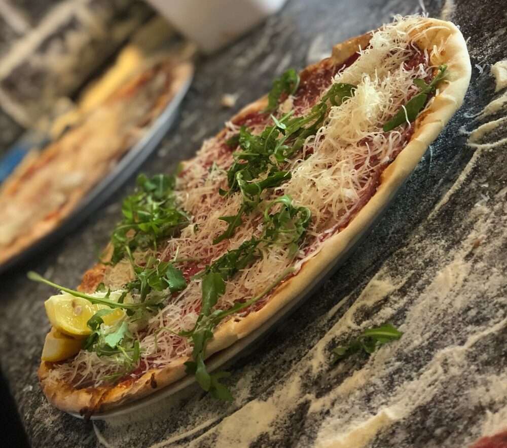 Long pizza baked in a wood-fired oven