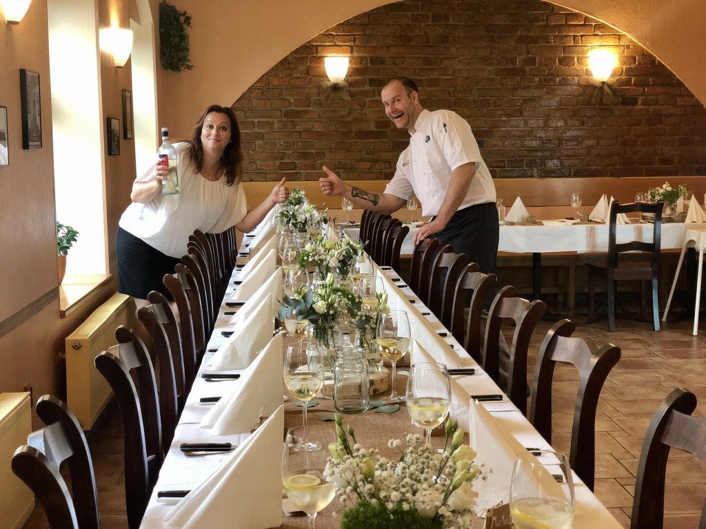 Obsluha restaurace u prostřeného stolu pro větší společnost