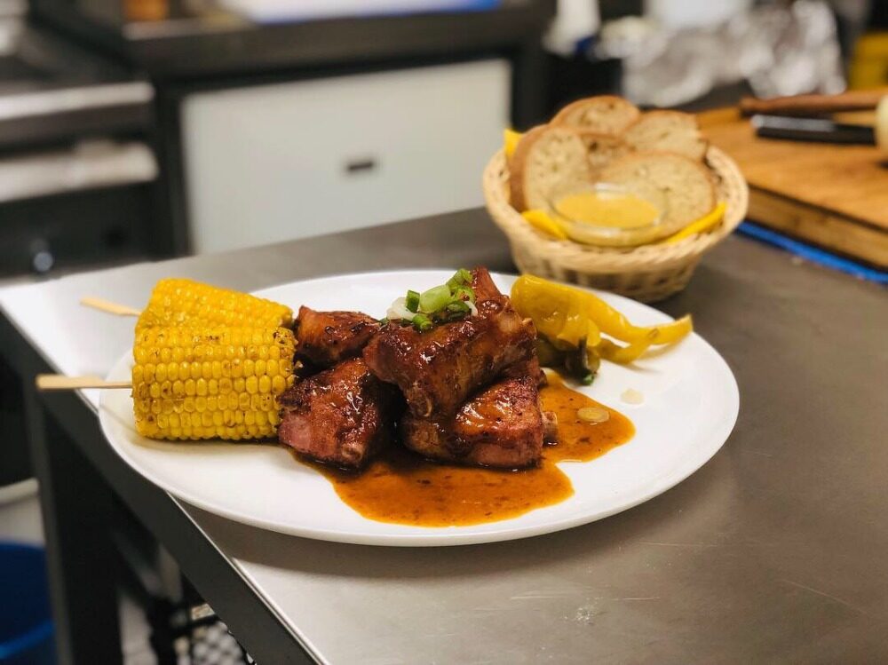 Steak s kukuřicí a hranolky na talíři